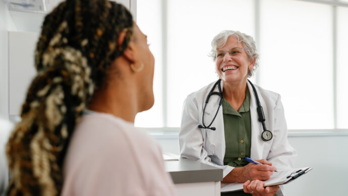 Older female physician speaks to patient